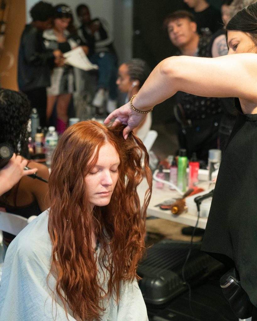 a woman getting her hair styled by a hair stylist